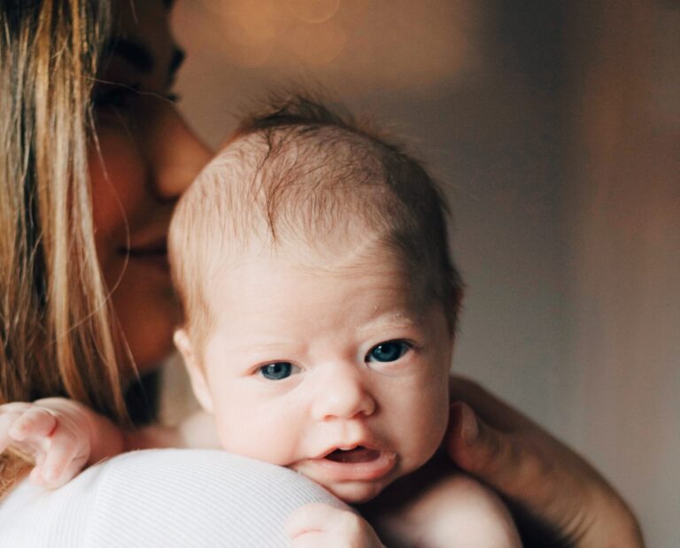 Szczęśliwa mama przytulająca noworodka