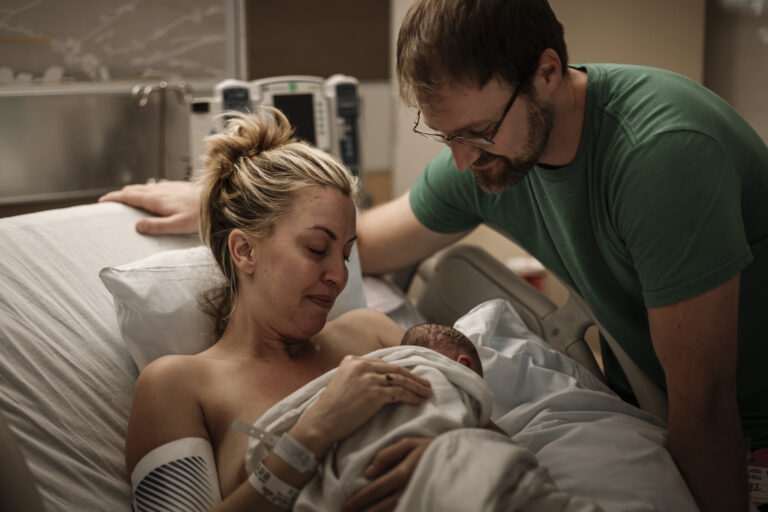 Kobieta z noworodkiem i mężem w szpitalu